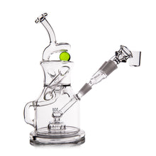 The MJ Arsenal The iLL-ien Dab Rig is a clear glass water pipe with multiple chambers, a bent neck, green spinning marble top accent, and detachable side bowl, shown against a white background.
