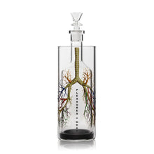 A clear glass Grav Gravitron bottle with a stopper, featuring an illustration of lungs and blood vessels. PLEASURES x GRAV is printed vertically on the front, marking this efficient smoking device inspired by the Grav Gravitron.