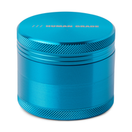 The Human Grade Grinder 1A (2" 4-Piece) is a metallic blue aluminum grinder with textured edges, a shiny finish, cylindrical design for durability, and "HUMAN GRADE" printed on top.