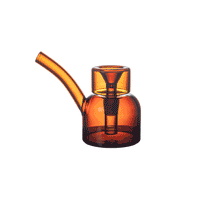 The NWTN Home Vesper Bubbler is a modern amber watering can crafted from borosilicate glass, featuring a curved spout and cylindrical handle, shown against a white background.
