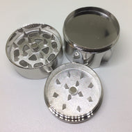 The 3 Piece Silver Grinder - 1.5" is shown disassembled on a white background, displaying sharp diamond-shaped teeth and a mesh screen inside—all parts sport a sleek, shiny finish.